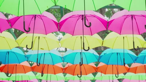 Walking under canopy of umbrellas in a park. Garden decor Stock Footage 279532074