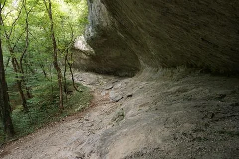 Walking under giant stone structure on the way to Bijela Canyon Foto stock