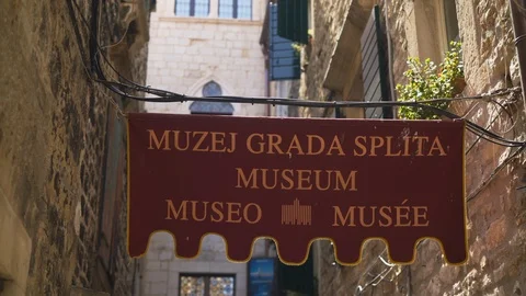 Walking under the name board of split city museum on Papaliceva Ulica, Vídeos de archivo 117551388
