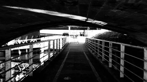 Walking under a small bridge in the city next to the river Video stock 171799855