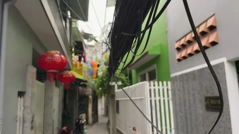 Walking under Tangled electrical wires hanging over narrow Asian street. Stock-Footage 339267667