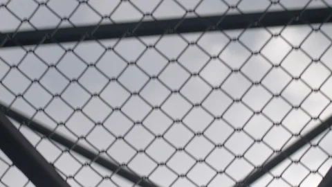 Walking underneath a chain link fenced in bridge 스톡 동영상 105625839