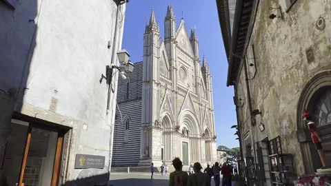 Walking view of Orvieto Cathedral framed by narrow streets Видео 302582091
