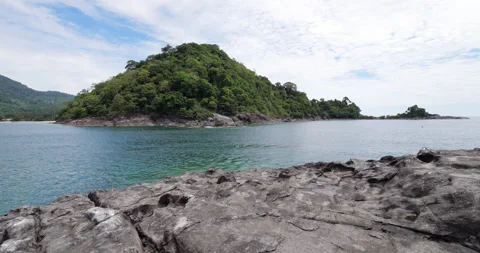 Walking on volcanic islet looking to water and east coast of Tioman Island Stock Footage 314770201
