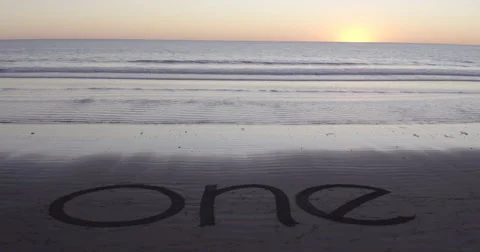 Walking walking into the word one written on the beach Stock Footage 58649496
