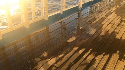 Walking on wet ship deck beautiful golden sunrise reflecting on ocean surface Stock Footage 97179426
