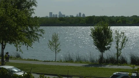 Walking at White Rock Lake park with Dallas skyline Stock Footage