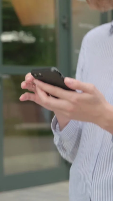 Walking Woman Using Smartphone, Browsing Internet, Vertical Video Stock Footage 339669716