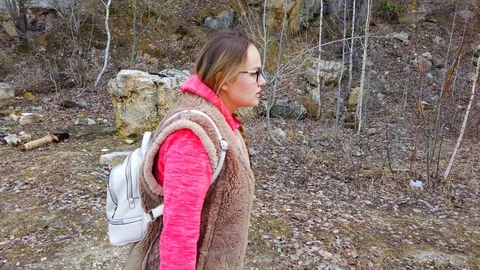 Walking women in the forest. View from the side, walking with a backpack through Stock Footage 128982905