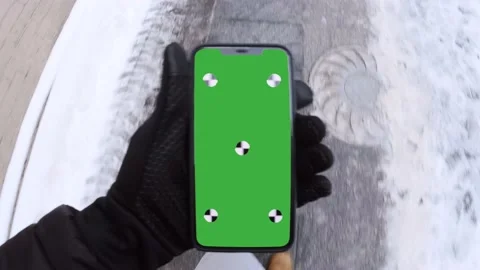 Walks in winter along a path trampled by snow, looking into a chroma phone Video stock 148942234