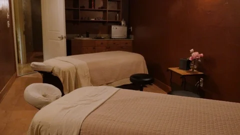 Walkthrough massage room two beds camera steadycam accros pulling out of room Vídeos de archivo 89385546