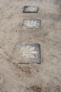 Walkway with black and white tiles that have flowers on them Stock Photos