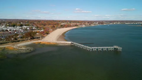 Walkway bridge extends out to ocean during fall, Norwalk, CT - 4K Aerial drone Stock Footage 289489544