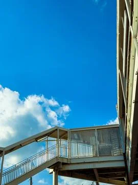 A walkway connects the ground to the second level of a structure. The sky is  Stock Photos