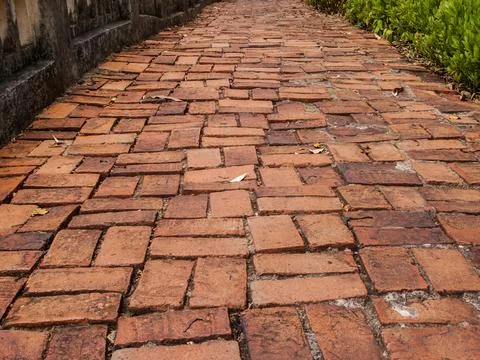 The walkway is paved with ancient red bricks. Stock Photos