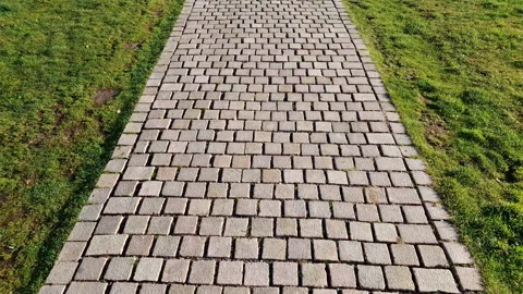 Walkway paved with cobblestone - grey stone cubes AKA Belgian setts: pattern and Stock Footage 231813896