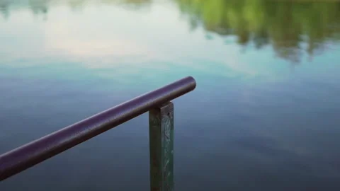 Walkway pole by the river in focus and slowly blurs to focus on the river Video stock 280123494