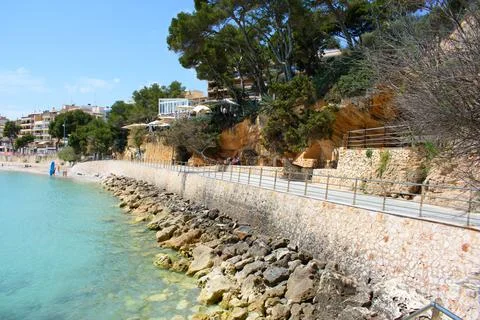 Walkway with railing next to coastal cliffs in Porto Cristo Stock Photos