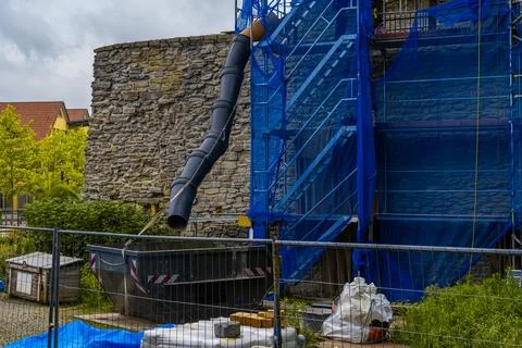 Wall of an ancient castle made of torn stone under scaffolding for repair. Stock Photos
