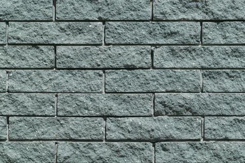 The wall and the bricks are gray or green. Stock Photos
