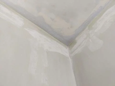 Wall and ceiling corner with putty repair and light off white base color Stock Photos