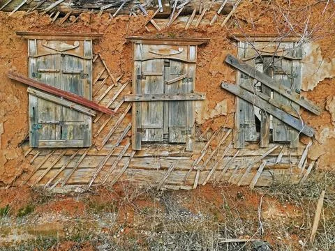 Wall and shutters of crumbling adobe house Stock Photos