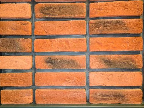 Wall background made of orange-colored bricks. Stock Photos