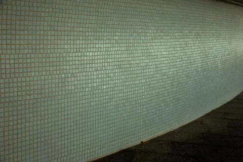 Wall background with an old ruined ceramic Venetian mosaic. Background of a w Stock Photos