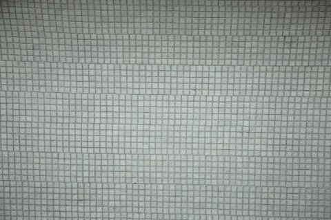 Wall background with an old ruined ceramic Venetian mosaic. Background of a w Stock Photos