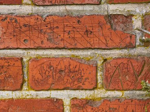 Wall background, writing and scratch on brick of building in city for texture Fotos de archivo