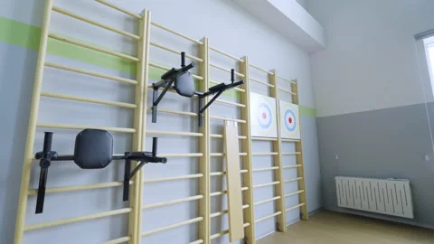 Wall bars with dip stations and targets mounted in gym Stock Footage 334683167