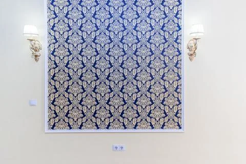 A wall with a blue and gold patterned wallpaper Stock Photos