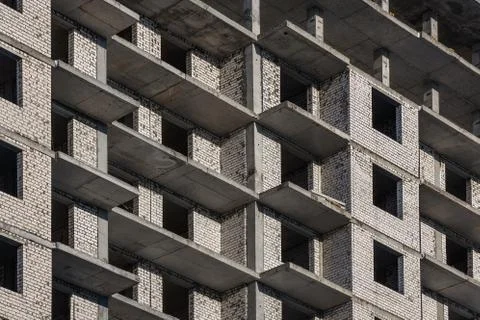 The wall of a brick building under construction. Windows and balconies of a n Stock Photos