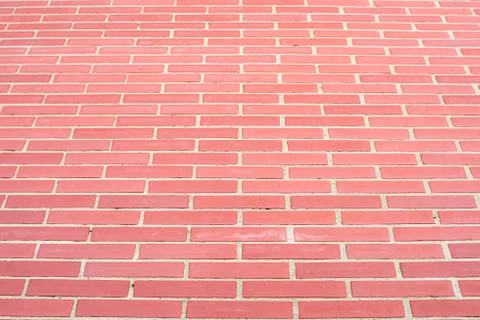 Wall of bricks and cement, reddish in color, forming a high and uniform wall Stock Photos
