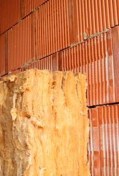Wall of bricks and insulation wool. Building with cavity wall insulation. Clo Stock Photos