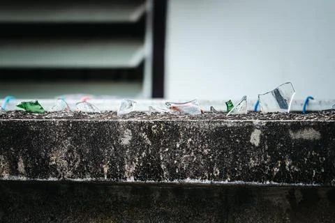 A wall with broken glass on it Stock Photos