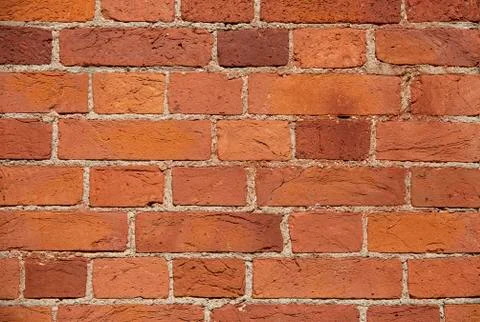 The wall of the building is made of old red brick. Background for text, posters Stock Photos