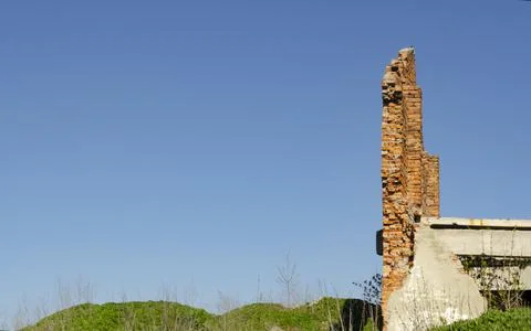 The wall of the building is a side view with a pile of red brick debris and c Stock Photos