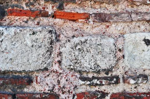 The wall is built of large stone blocks and red bricks. Stock Photos