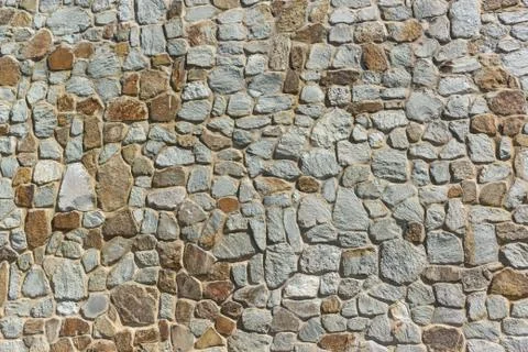 The wall, built of natural stone Stock Photos