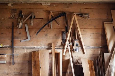 Wall in the carpentry workshop with many tools and planks of wood, as well .. Stock Photos