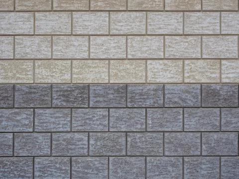 Wall cladding in rough gray and beige tiles imitating masonry. Not seamless 스톡 사진