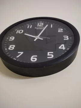 Wall clock on a black background showing time 스톡 사진