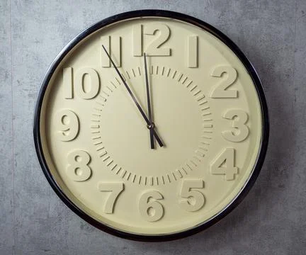 Wall clock on a gray background. Clock close up. Stock Photos