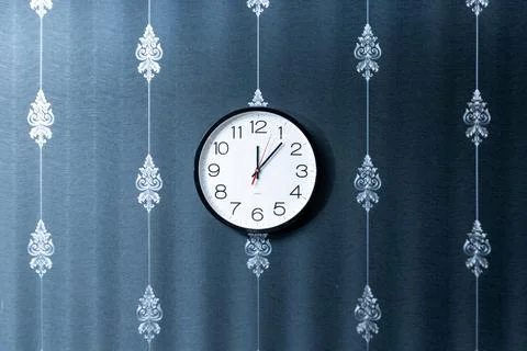 A wall clock with the hands on the number 3 and 9 Stock Photos