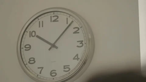 Wall clock with head in foreground Vídeos de archivo 334049955