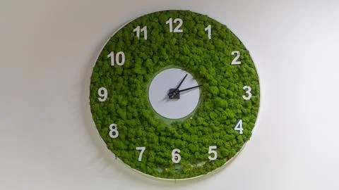 A wall with a clock made of grass Stock Photos