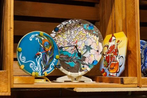 Wall clock made using stained glass technique on shelf in art shop. Novosibir Stock Photos