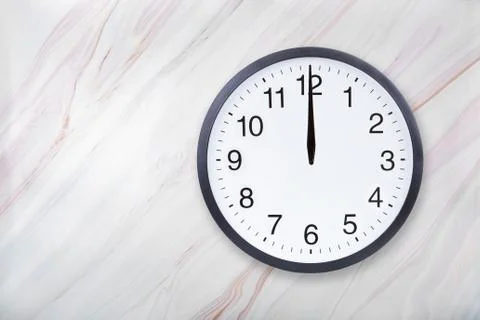 Wall clock on marble texture show twelve o'clock. Office clock show midday or Stock Photos
