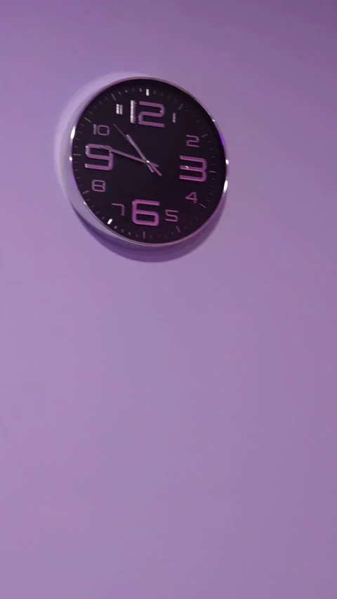 Wall clock on purple background with copy space. Vertical layout of modern .. Stock Footage 337346778